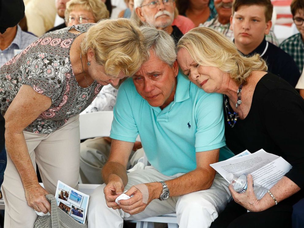 PHOTO: Carl Hiaasen, center, brother of Rob Hiaasen, is consoled by his sister Judy, right, during a memorial service, July 2, 2018, in Owings Mills, Md.