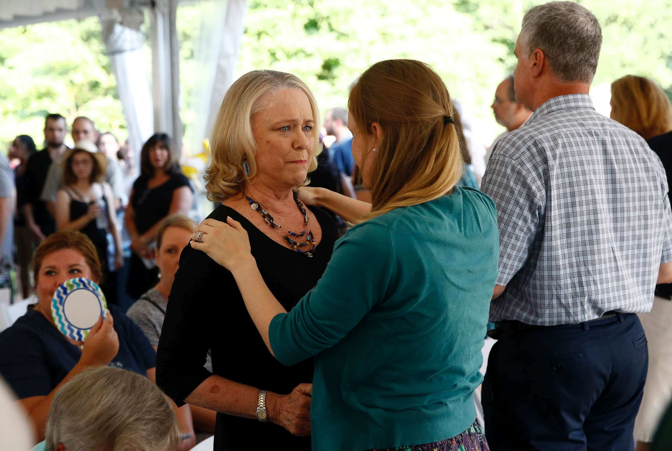 PHOTO: Judy Hiaasen, left, sister of Rob Hiaasen, one of the journalists killed in the shooting at The Capital Gazette newspaper offices, speaks with a mourner during a memorial service, July 2, 2018, in Owings Mills, Md.