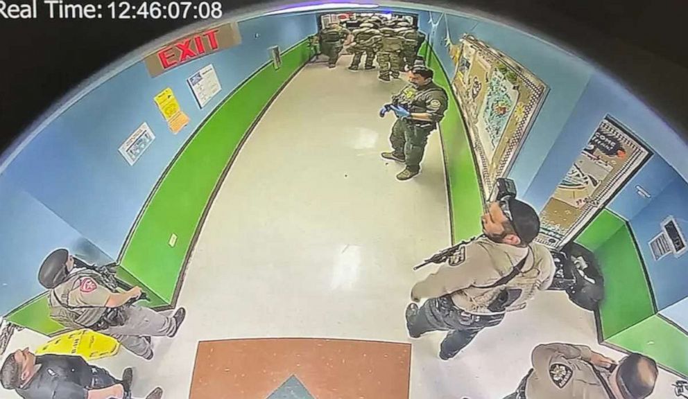 PHOTO: In this image first obtained by The New York Times, officers gather in the hallway of Robb Elementary School in Uvalde, Texas on May 24, 2022. The timestamp of 12:46 p.m. can be seen in the image.