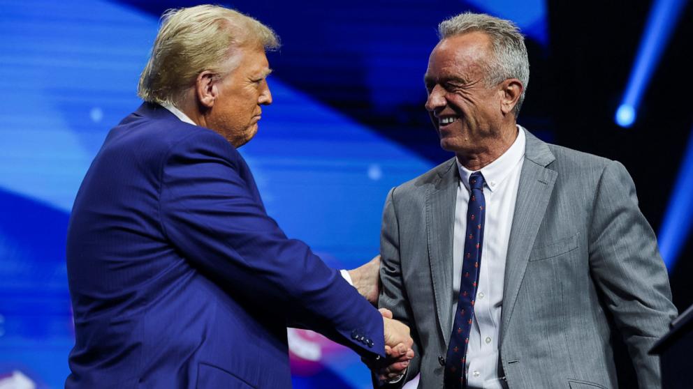 PHOTO: Robert F. Kennedy Jr. and Republican presidential nominee and former U.S. President Donald Trump greet each other at a campaign event sponsored by conservative group Turning Point USA, in Duluth, Georgia, Oct. 23, 2024. 