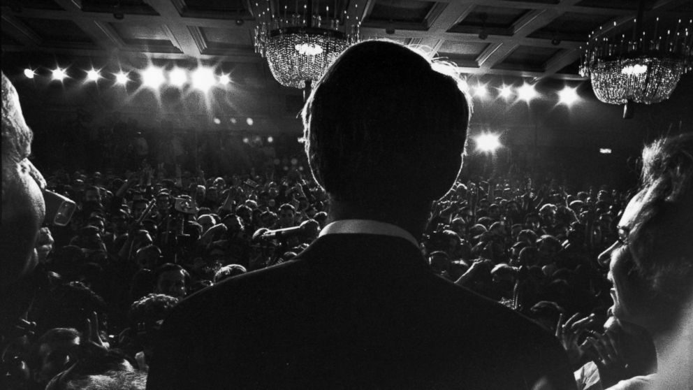 PHOTO: Rear view of Sen. Robert Kennedy and his pregnant wife Ethel standing at a podium at the Ambassador Hotel as he addresses supporters  after his California primary election victory, Los Angeles, June 5, 1968.