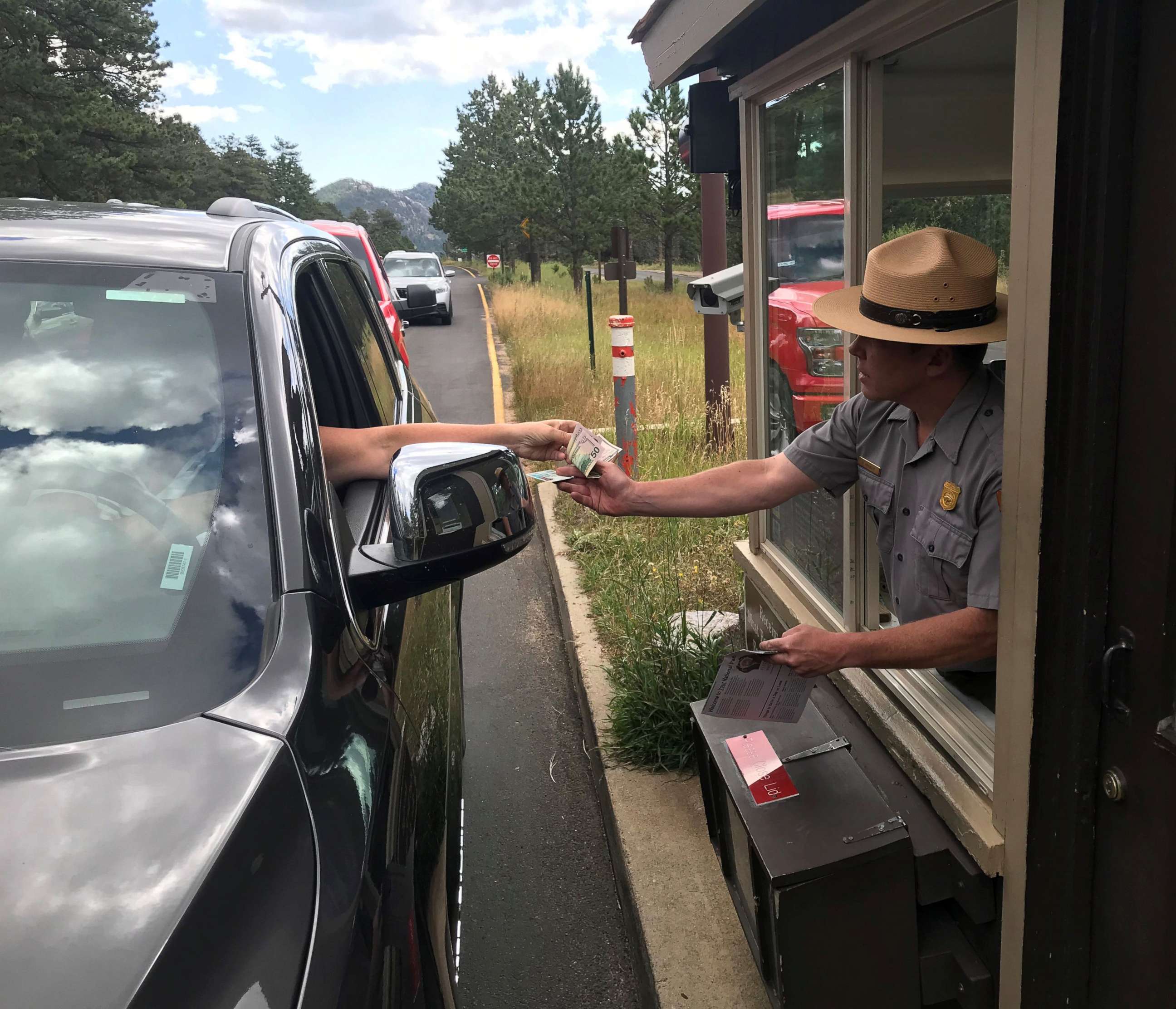 PHOTO: A Rocky Mountain National Park ranger takes money from a visitor at the Fall River entrance on Sept. 18, 2019, in Colorado.