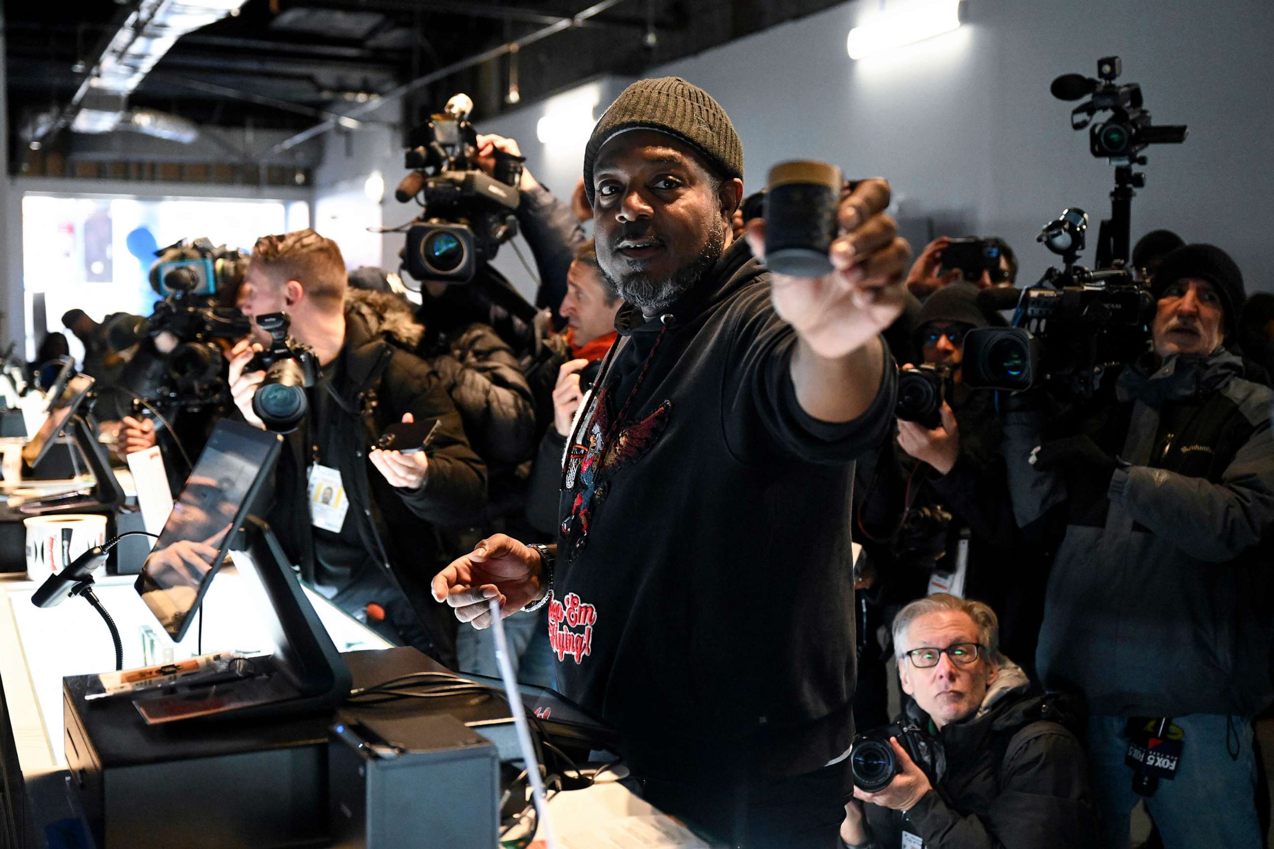 PHOTO: In this Jan. 24, 2023, file photo, owner Roland Conner makes the first marijuana purchase from his son Darius at the opening of Smacked LLC, the first New York cannabis dispensary owned by a justice impacted individual in New York.