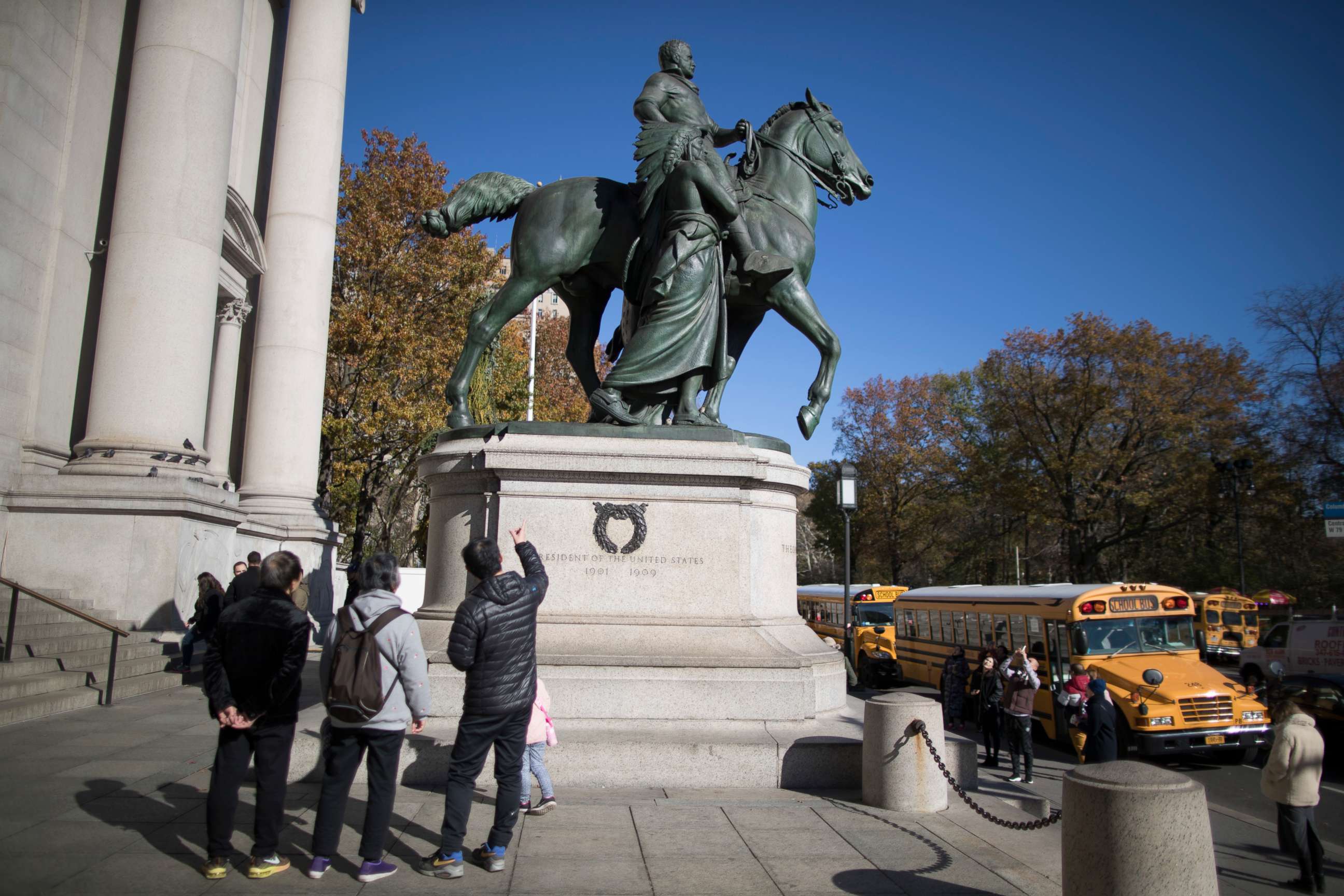 PHOTO: In this Nov. 17, 2017 file photo, visitors to the American Museum of Natural History in New York look at a statue of Theodore Roosevelt, flanked by a Native American man and African American man. 