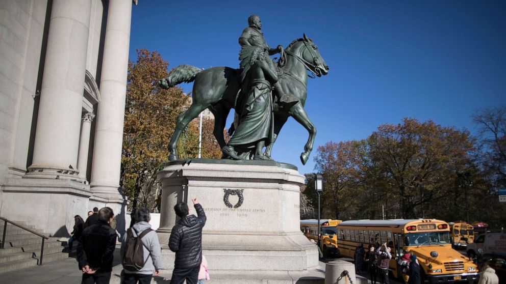 PHOTO: In this Nov. 17, 2017 file photo, visitors to the American Museum of Natural History in New York look at a statue of Theodore Roosevelt, flanked by a Native American man and African American man.