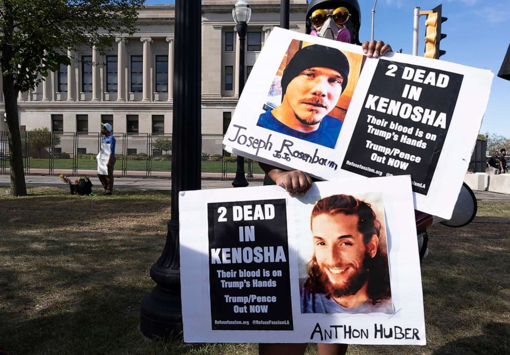 PHOTO: A protester holds posters showing images of Anthony Huber and Joseph Rosenbaum, who were killed during a march in Kenosha, Wis., Aug. 29, 2020. Eighteen-year-old Kyle Rittenhouse is charged for the deaths of the two men and the injuring of another.