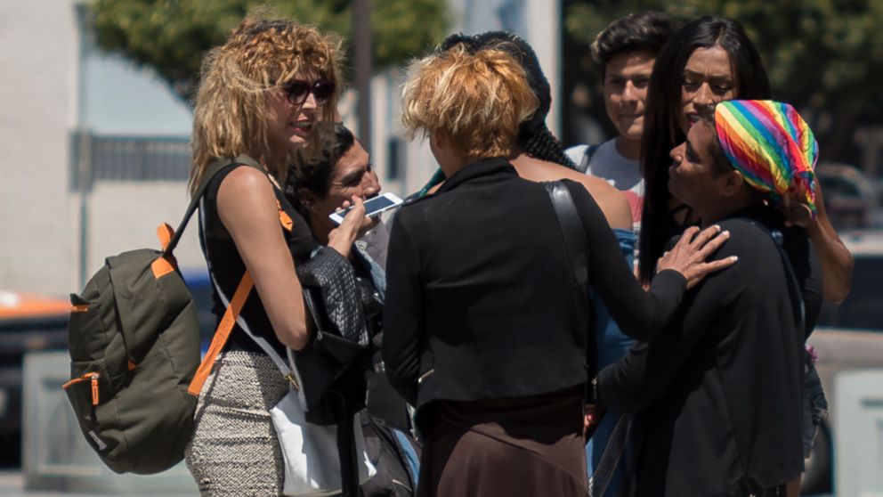 Roxana Hernandez a transgender woman, left, talks with her friends behind the community center called El Caracol, where legal aid was being offered  to migrants of the caravan by volunteer US lawyers in Tijuana, Mexico May 2018.