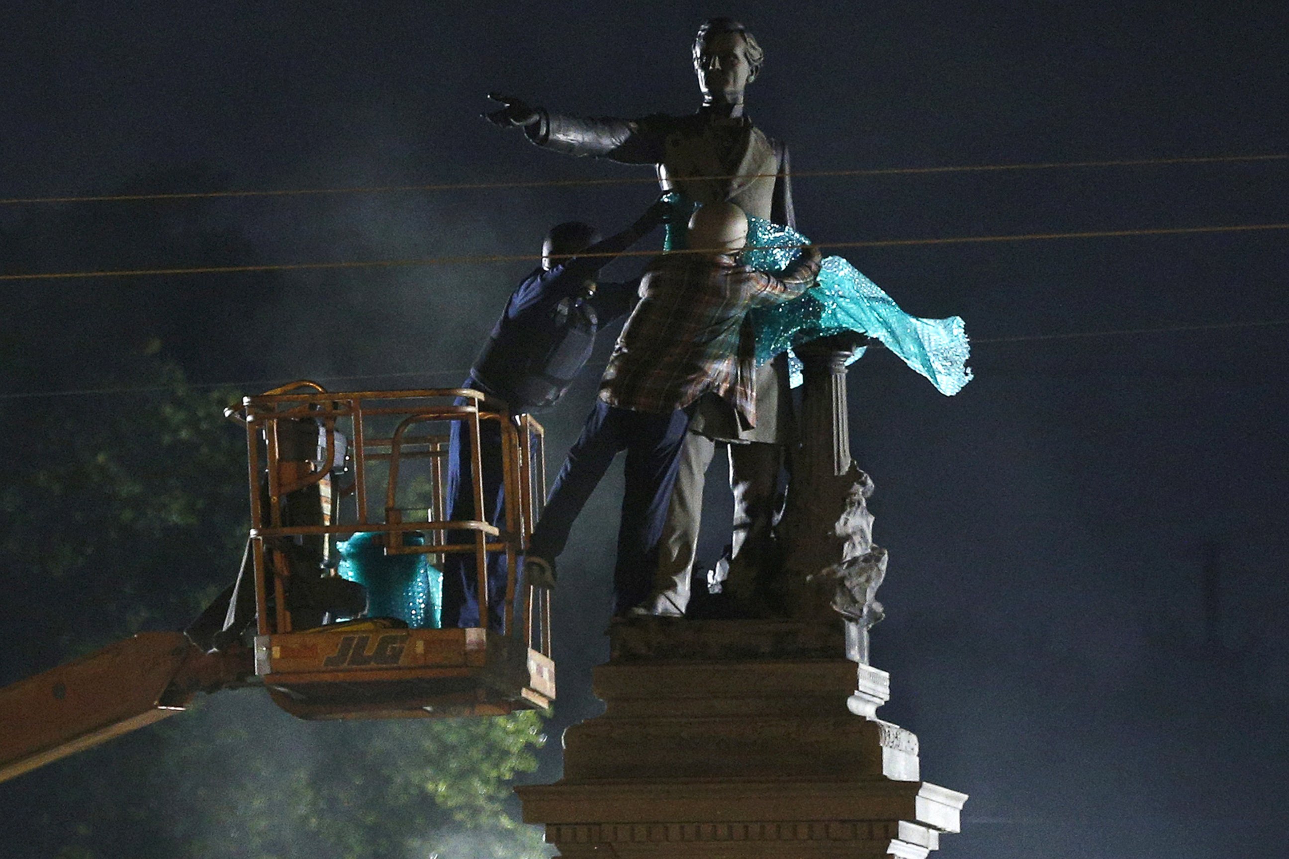 PHOTO: A construction crew works to remove a monument of Jefferson Davis in New Orleans, May 11, 2017. 