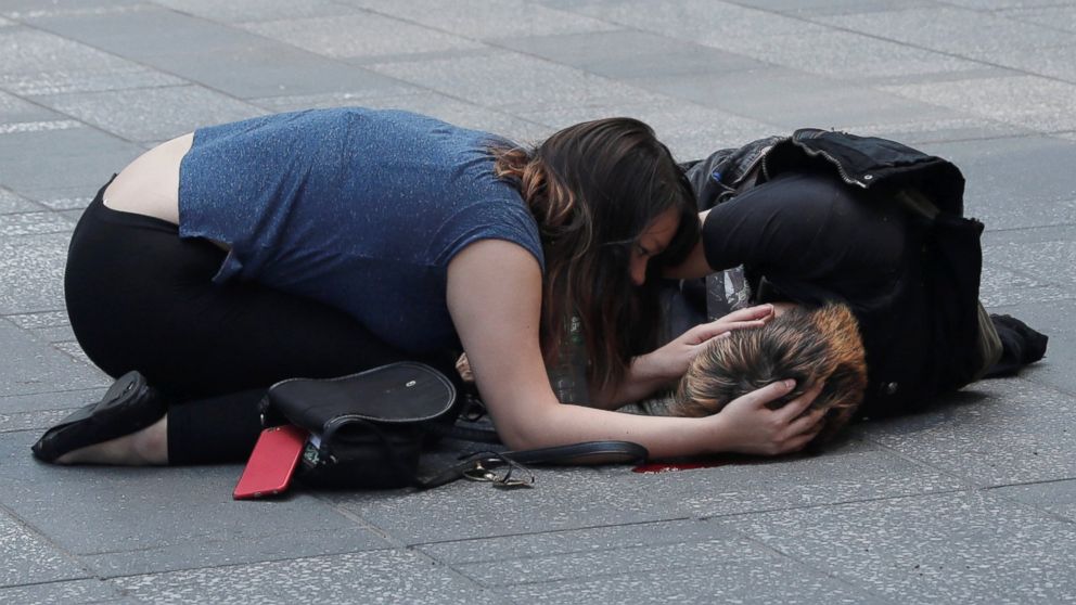 PHOTO: A woman attends to an injured man on the sidewalk in Times Square after a speeding vehicle struck pedestrians on the sidewalk in New York City, May 18, 2017. 