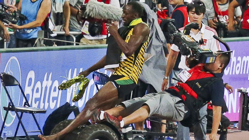 Usain Bolt of Jamaica is hit by a cameraman on a Segway as he celebrates after winning the men's 200 meters final at the 15th IAAF World Championships at the National Stadium in Beijing, China, August 27, 2015. 