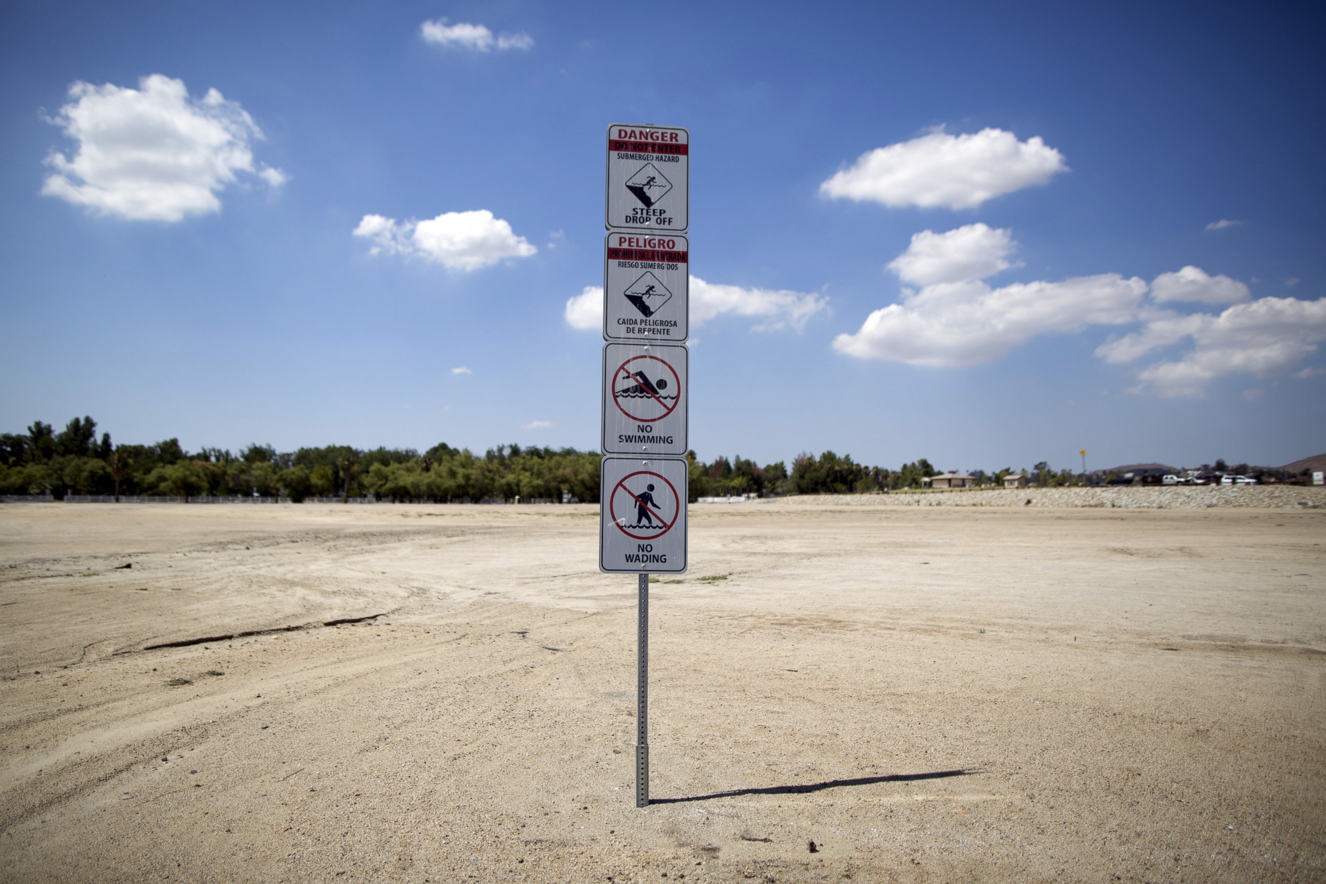 PHOTO: Signs warning of underwater hazards stand over a portion of dried up lake bed at Lake Elsinore in Lake Elsinore, Calif., July 23, 2015.