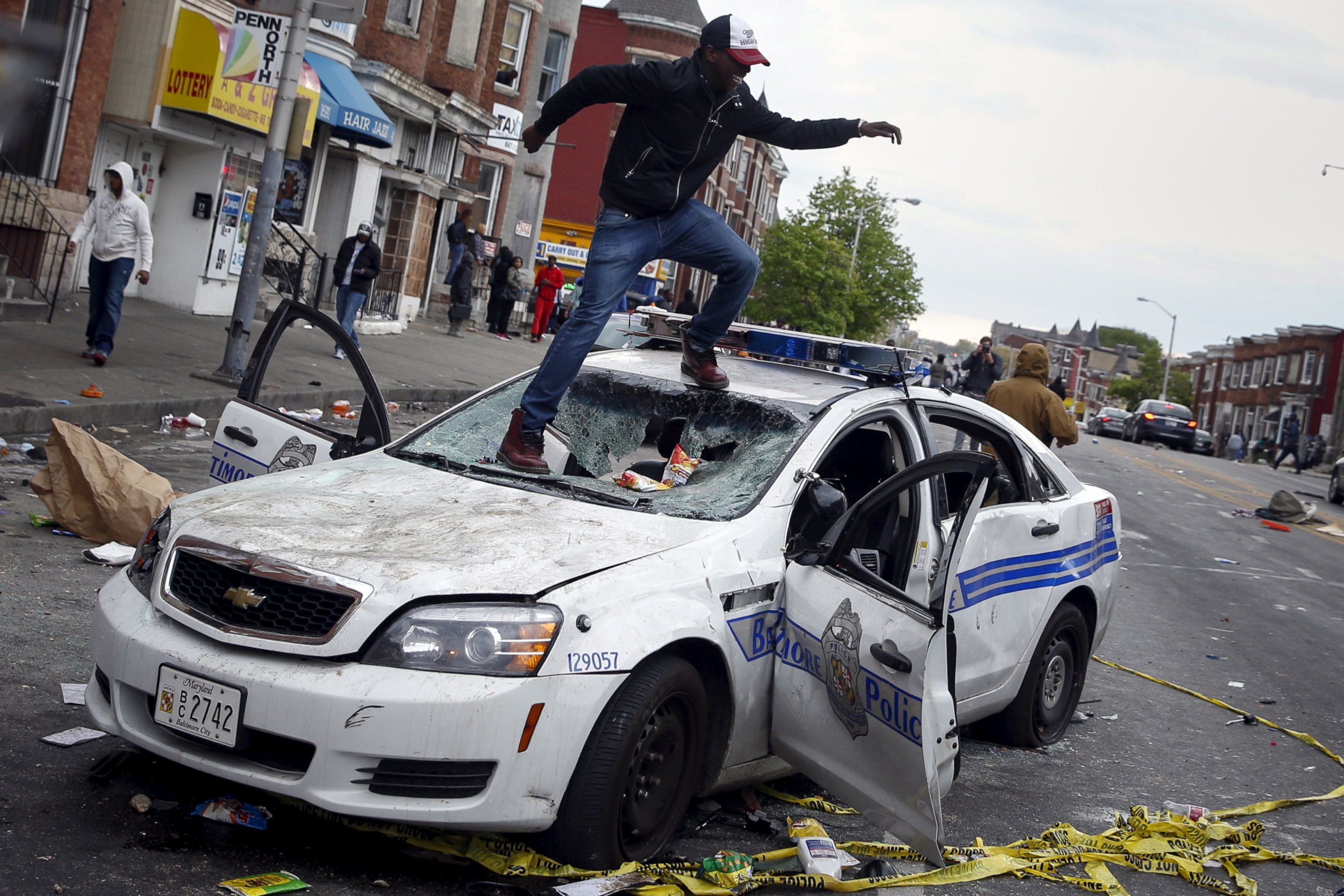 PHOTO: Demonstrators jump on a damaged Baltimore police department vehicle during clashes in Baltimore, Md., April 27, 2015.