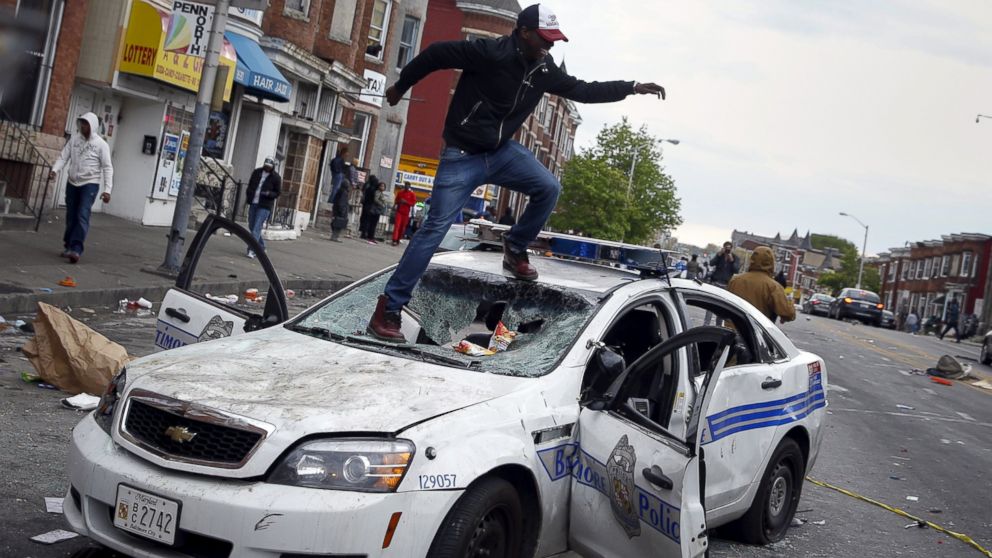PHOTO: Demonstrators jump on a damaged Baltimore police department vehicle during clashes in Baltimore, Md., April 27, 2015.