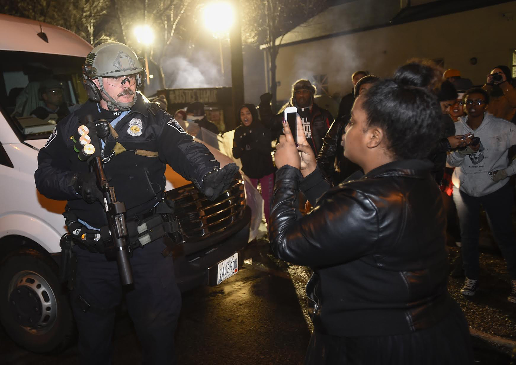 PHOTO: A police officer tells a women to back up as she photographs him in front of a north Minneapolis police precinct during a protest in response to Sunday's shooting death of Jamar Clark by police officers in Minneapolis, Nov. 18, 2015.