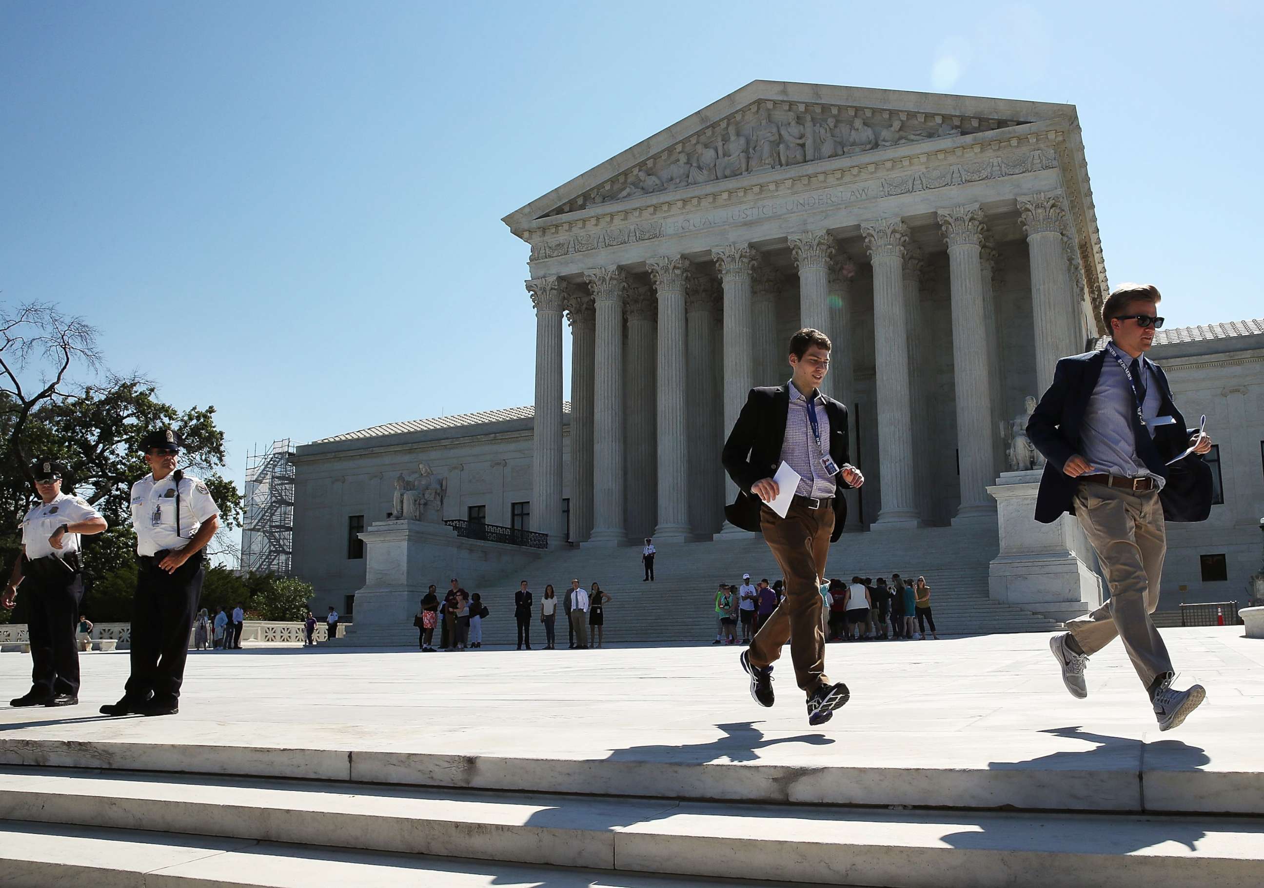 PHOTO: Two CBS interns run with a newly released Supreme Court ruling June 20, 2016 in Washington. 