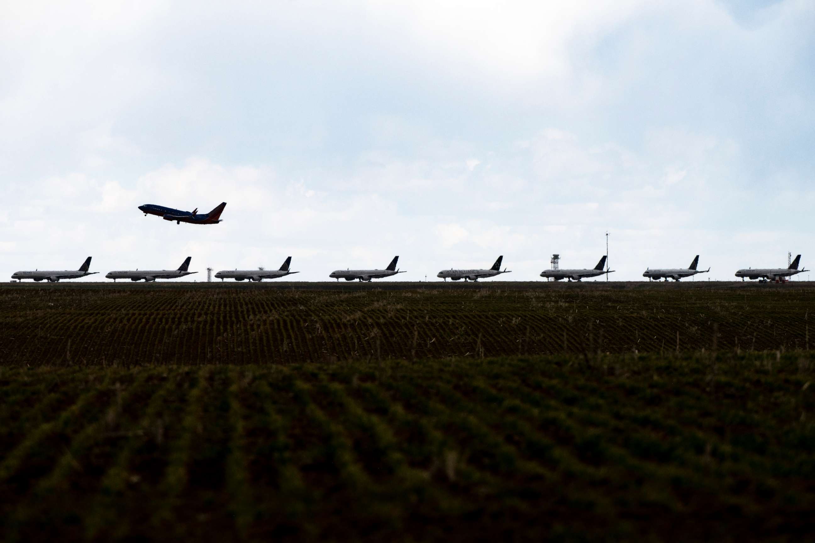 PHOTO: A Southwest Airlines flight takes off as United Airlines planes sit parked on a runway at Denver International Airport as the coronavirus pandemic slows air travel on April 22, 2020 in Denver, Colorado.