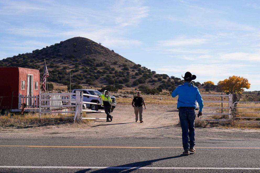 PHOTO: A worker, who said he came to pick up some equipment, walks toward security guards at the entrance to the Bonanza Creek Ranch film set in Santa Fe, N.M., Oct. 25, 2021.