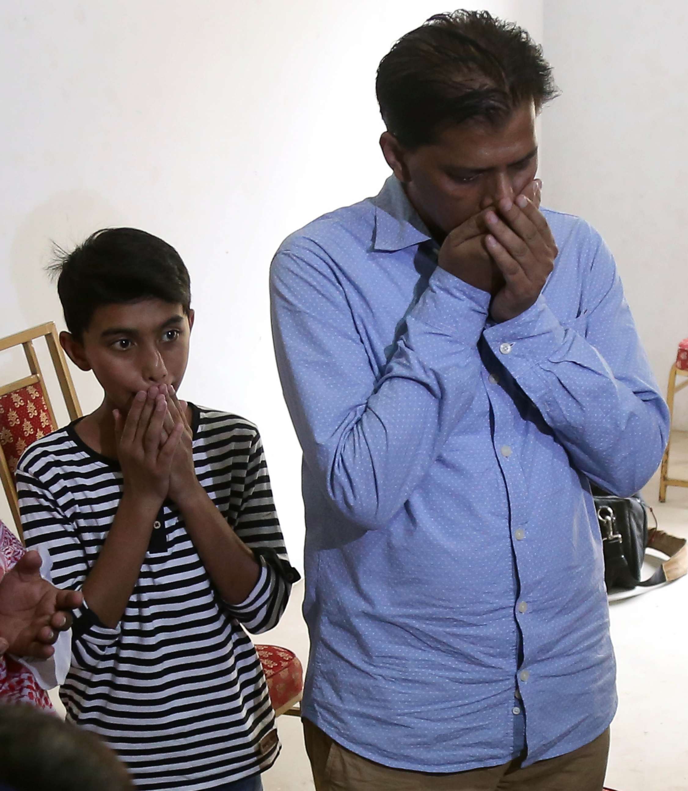PHOTO: Abdul Aziz Sheikh, the father of Sabika Sheikh, with his son Ali, mourn the loss of his daughter, May 19, 2018.  Sheikh was an exchange student from Pakistan and was one of the ten students killed in the school shooting in Santa Fe, Texas.