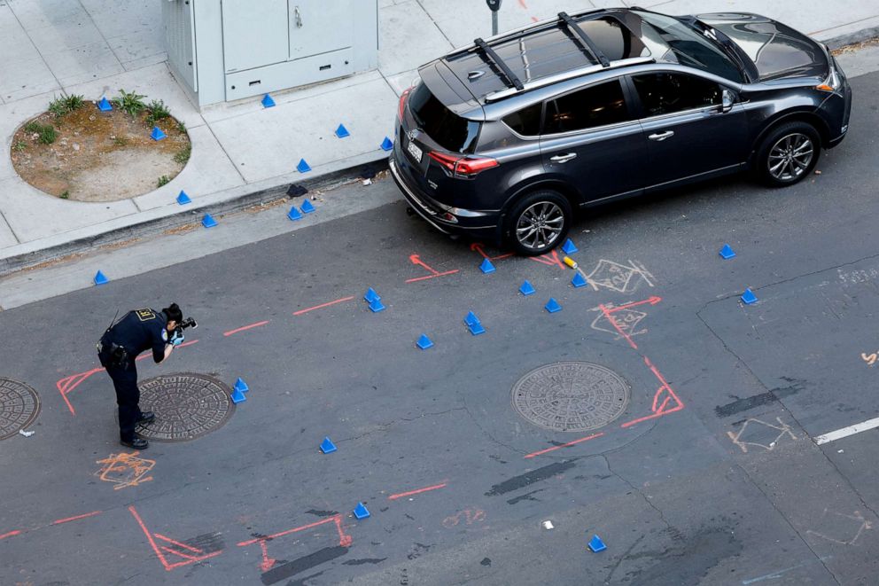 PHOTO: A police evidence technician photographs the crime scene after an early-morning shooting in a stretch of downtown near the Golden 1 Center arena in Sacramento, Calif., April 3, 2022. 