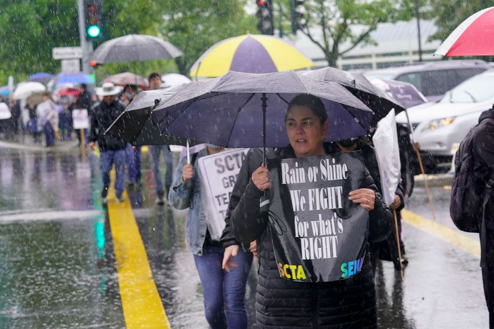 PHOTO: Chris McCarthy, a first grade teacher in the Sacramento Unified School District, joined other teachers, parents, students in the rain at a rally in support of a district teachers strike at Rosemont High School in Sacramento, Calif., March 28, 2022.
