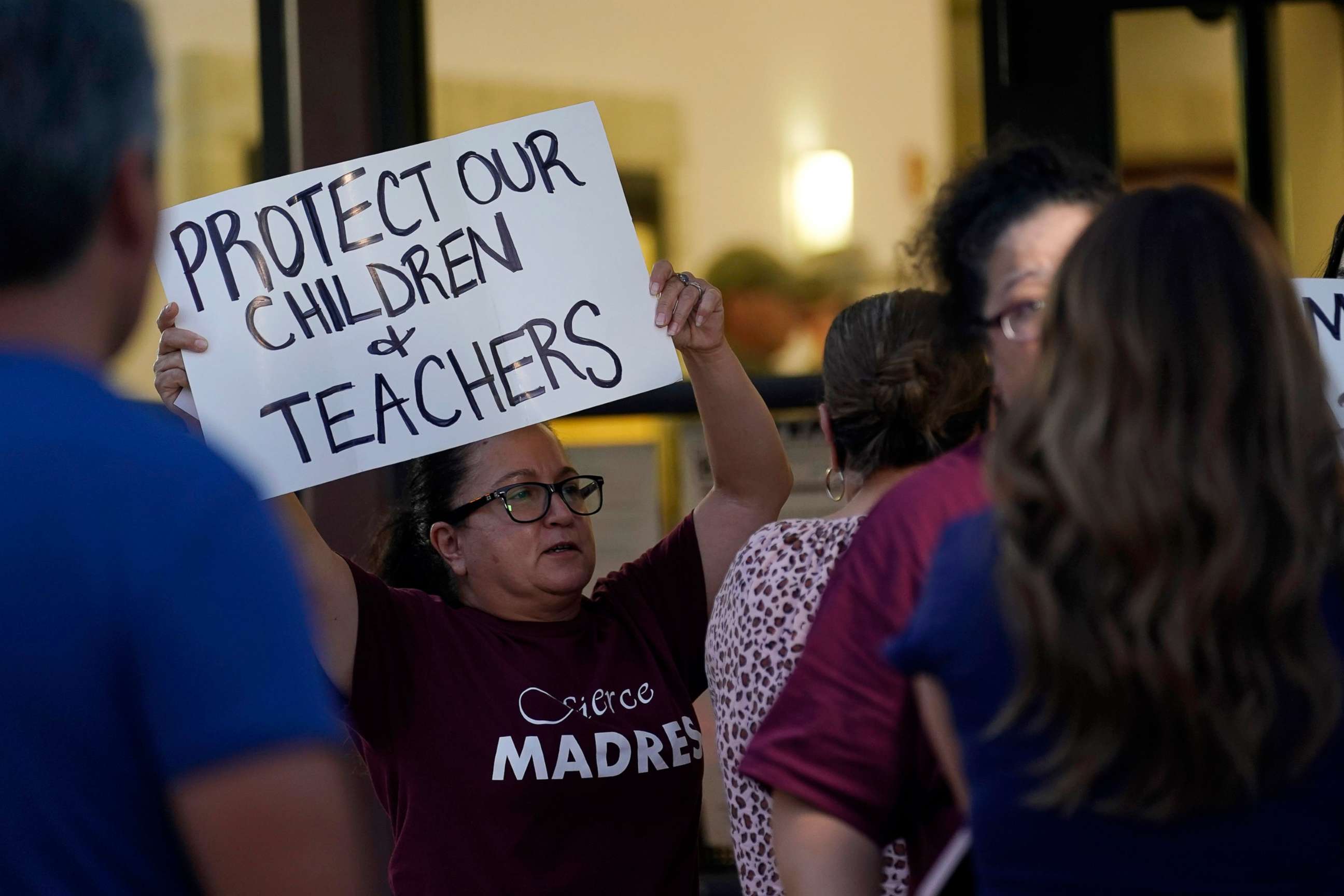 PHOTO: Parents and family of students hold signs including one reading "Protect our children & teachers" during a special meeting of the Board of Trustees of Uvalde Consolidated Independent School District, July 18, 2022, in Uvalde, Texas.