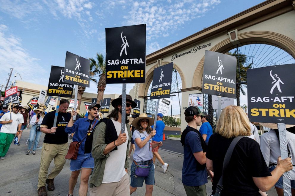 PHOTO: SAG-AFTRA actors and Writers Guild of America (WGA) writers walk the picket line in front of Paramount Studios in Los Angeles, California, July 17, 2023.