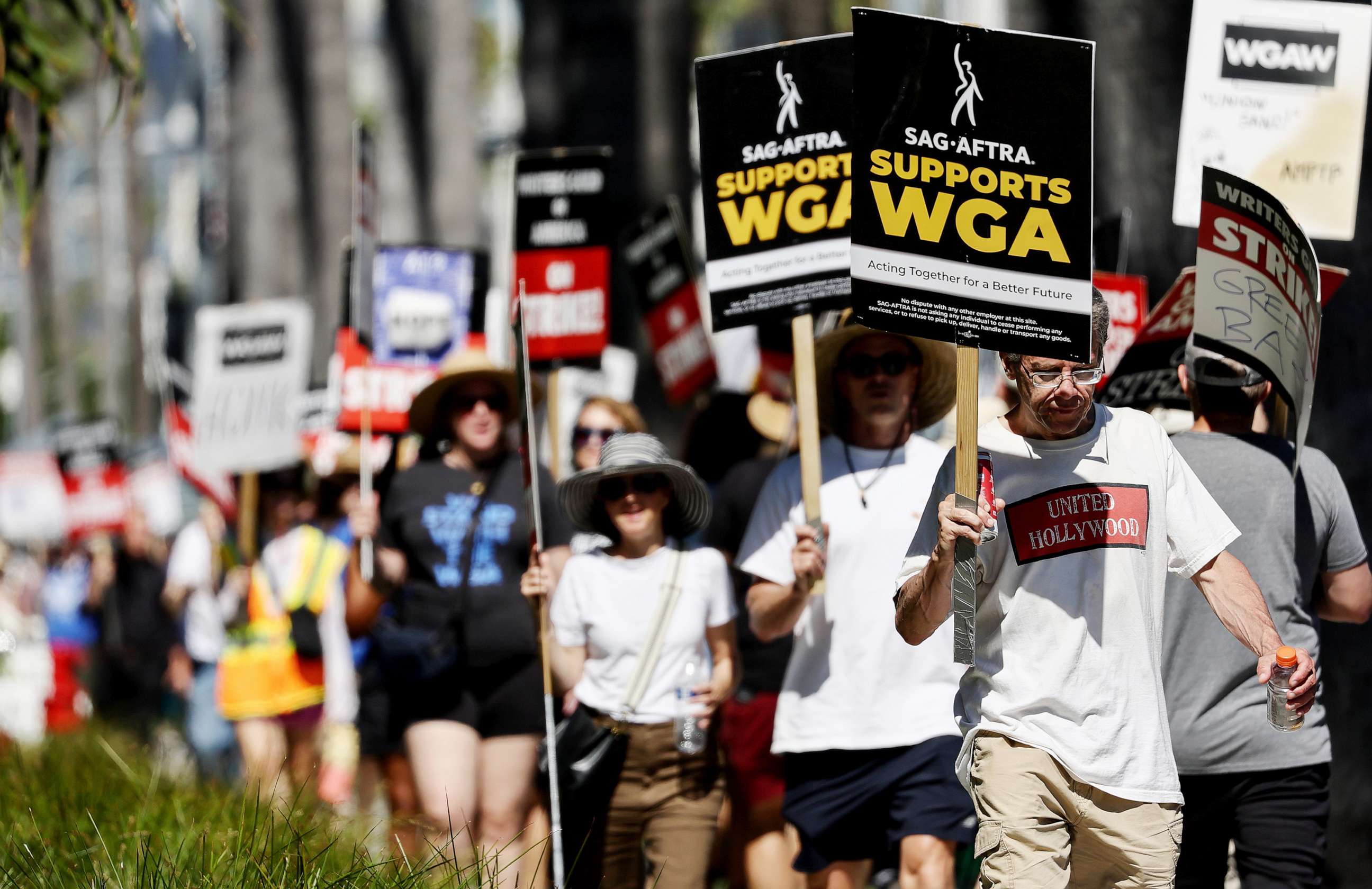 PHOTO: A sign reads 'SAG-AFTRA Supports WGA' as SAG-AFTRA members walk the picket line in solidarity with striking WGA (Writers Guild of America) workers outside Netflix offices on July 13, 2023 in Los Angeles.