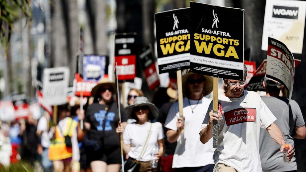 PHOTO: A sign reads 'SAG-AFTRA Supports WGA' as SAG-AFTRA members walk the picket line in solidarity with striking WGA (Writers Guild of America) workers outside Netflix offices on July 13, 2023 in Los Angeles.