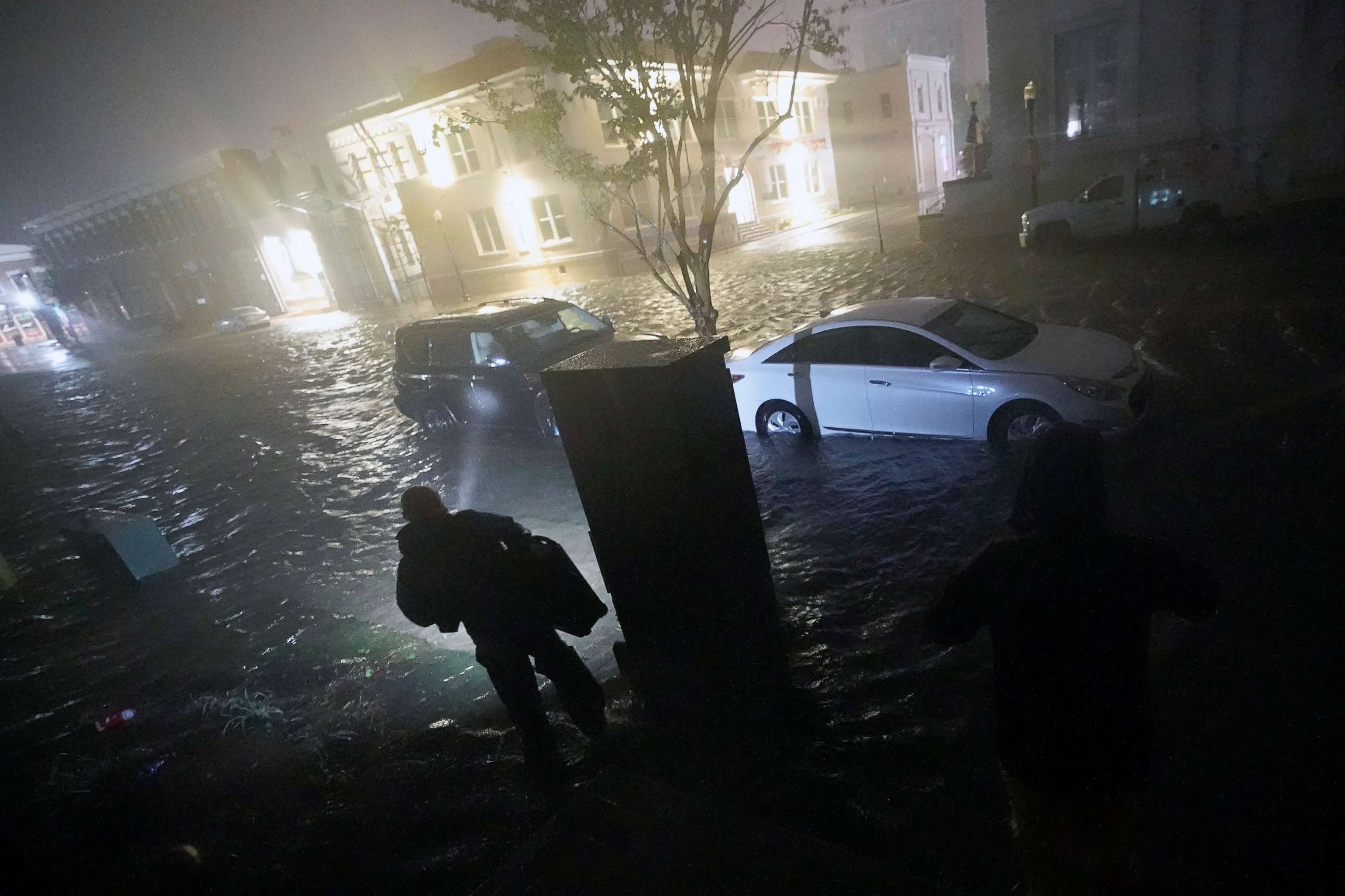 PHOTO:People use flashlights as they walk on flooded streets in search of their vehicle, Sept. 16, 2020, in Pensacola, Fla. 