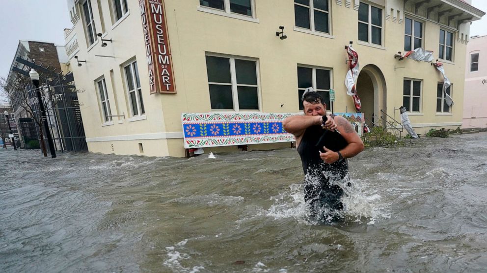 PHOTO: Trent Airhart wades through flood waters, Sept. 16, 2020, in downtown Pensacola, Fla.