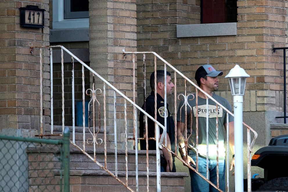 PHOTO: A New Jersey police officer and a plain-clothed police officer exit the building where alleged attacker of Salman Rushdie, Hadi Matar, lives in Fairview, N.J.,  Aug. 12, 2022.