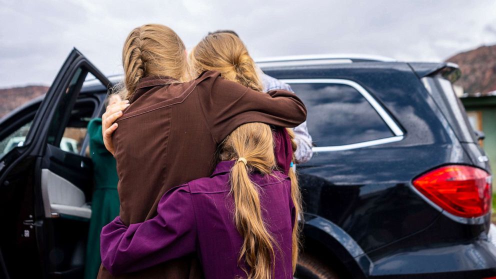 PHOTO: In this Sept. 14, 2022, file photo, three girls embrace before they are removed from the home of Samuel Bateman, following his arrest in Colorado City, Ariz.