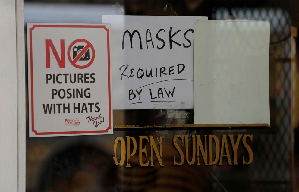 PHOTO: A sign instructing shoppers to wear masks to protect against the spread of COVID-19 is posted at a business in San Antonio, Wednesday, June 24, 2020. 