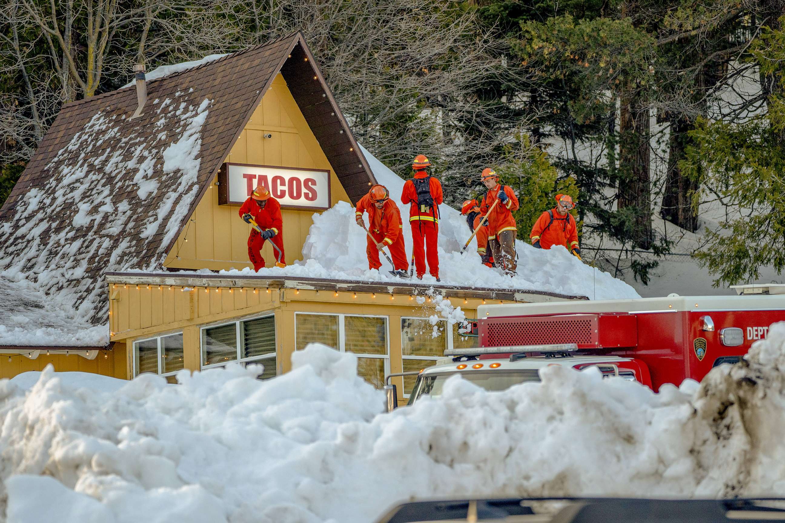 PHOTO: Inmate firefighters clear snow off the roof of a restaurant, March 7. 2023, in Lake Arrowhead, Calif.