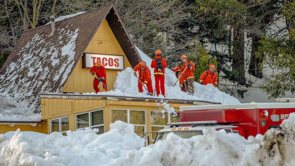 PHOTO: Inmate firefighters clear snow off the roof of a restaurant, March 7. 2023, in Lake Arrowhead, Calif.