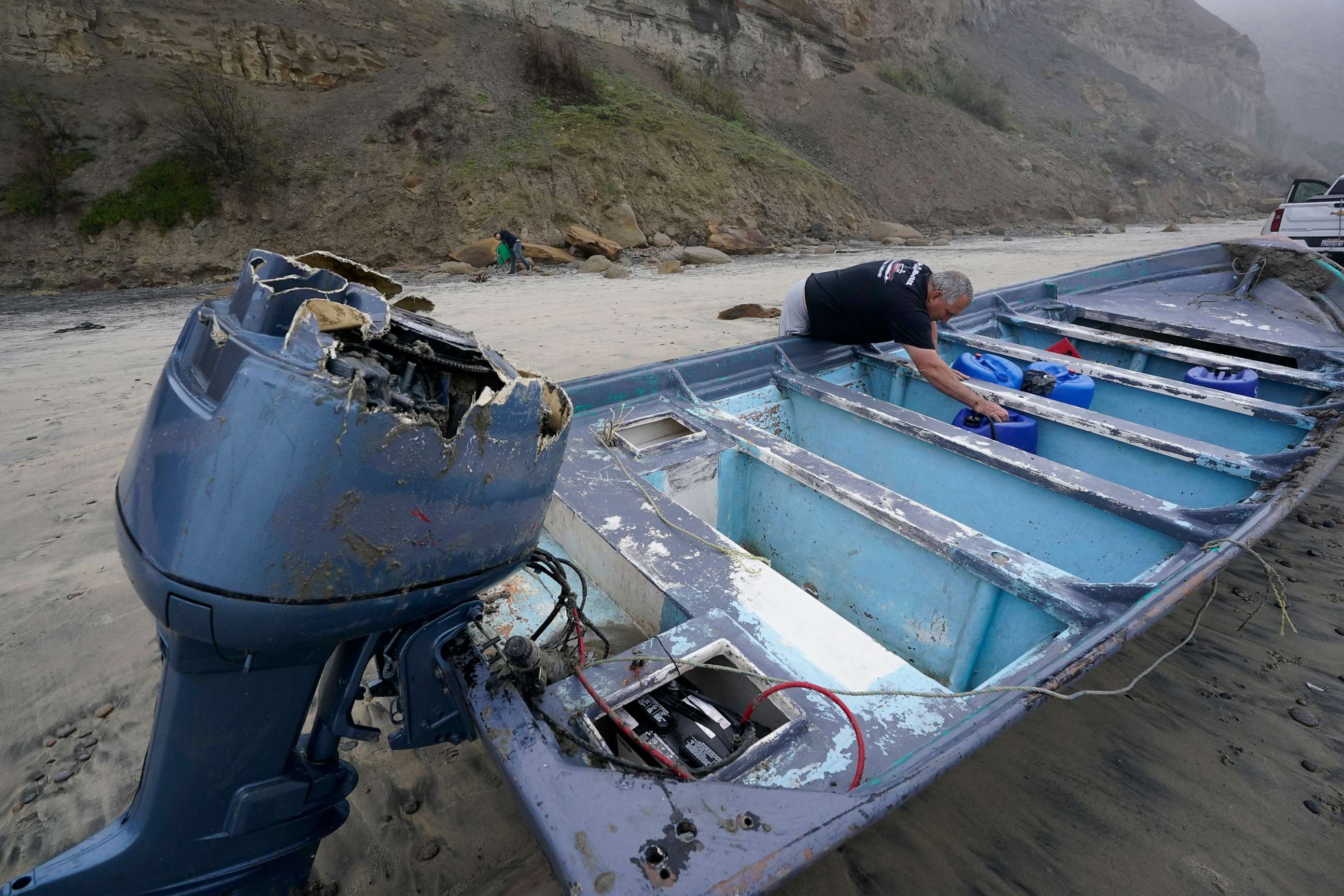 PHOTO: Boat salvager Robert Butler picks up a canister in one of one of two boats sitting on Blacks Beach, March 12, 2023, in San Diego.