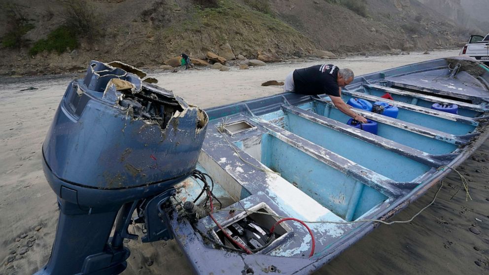 PHOTO: Boat salvager Robert Butler picks up a canister in one of one of two boats sitting on Blacks Beach, March 12, 2023, in San Diego.