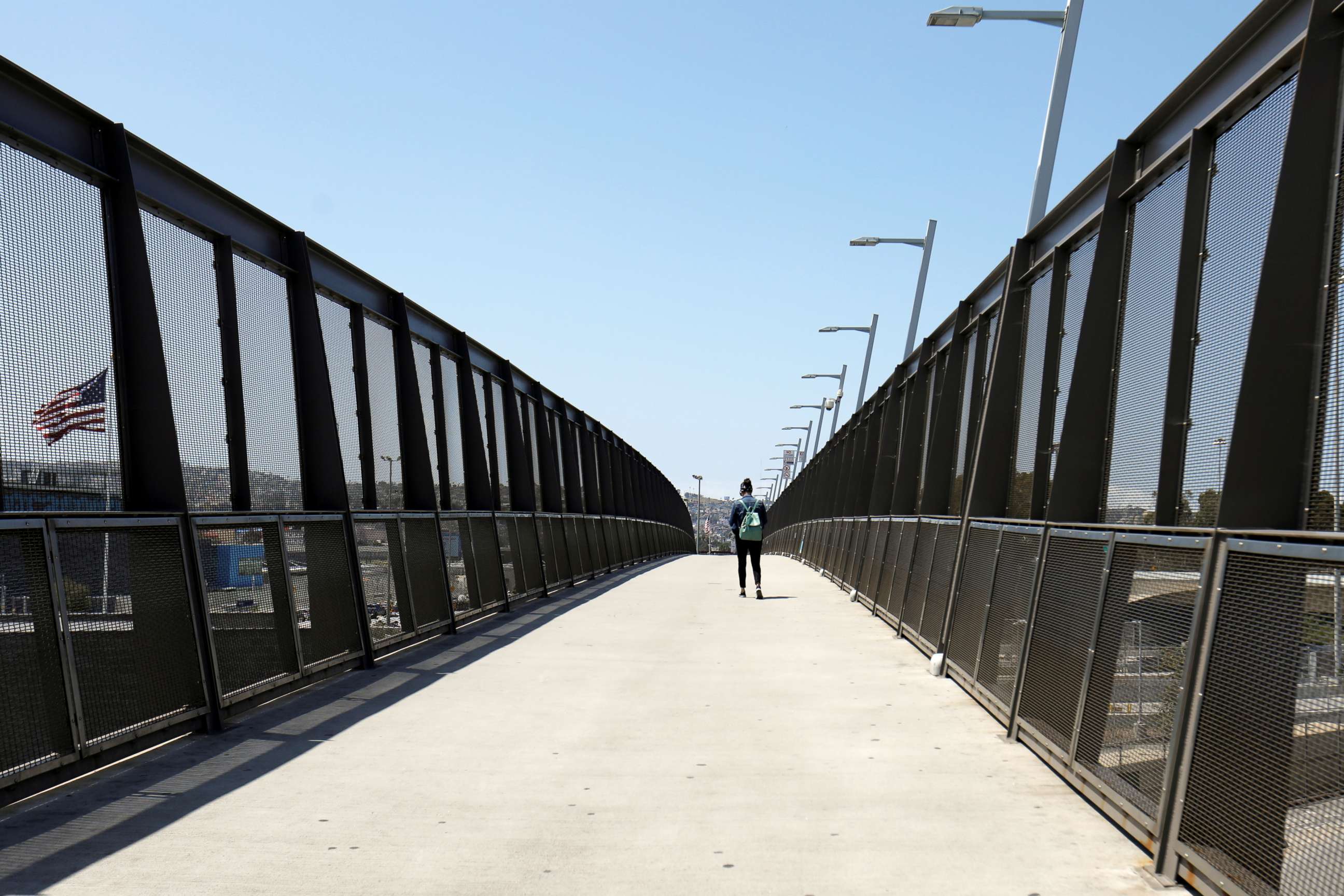 PHOTO: A lone pedestrian walks across the pedestrian bridge at the U.S.-Mexico border during the coronavirus disease (COVID-19) outbreak in San Diego, April 21, 2020.