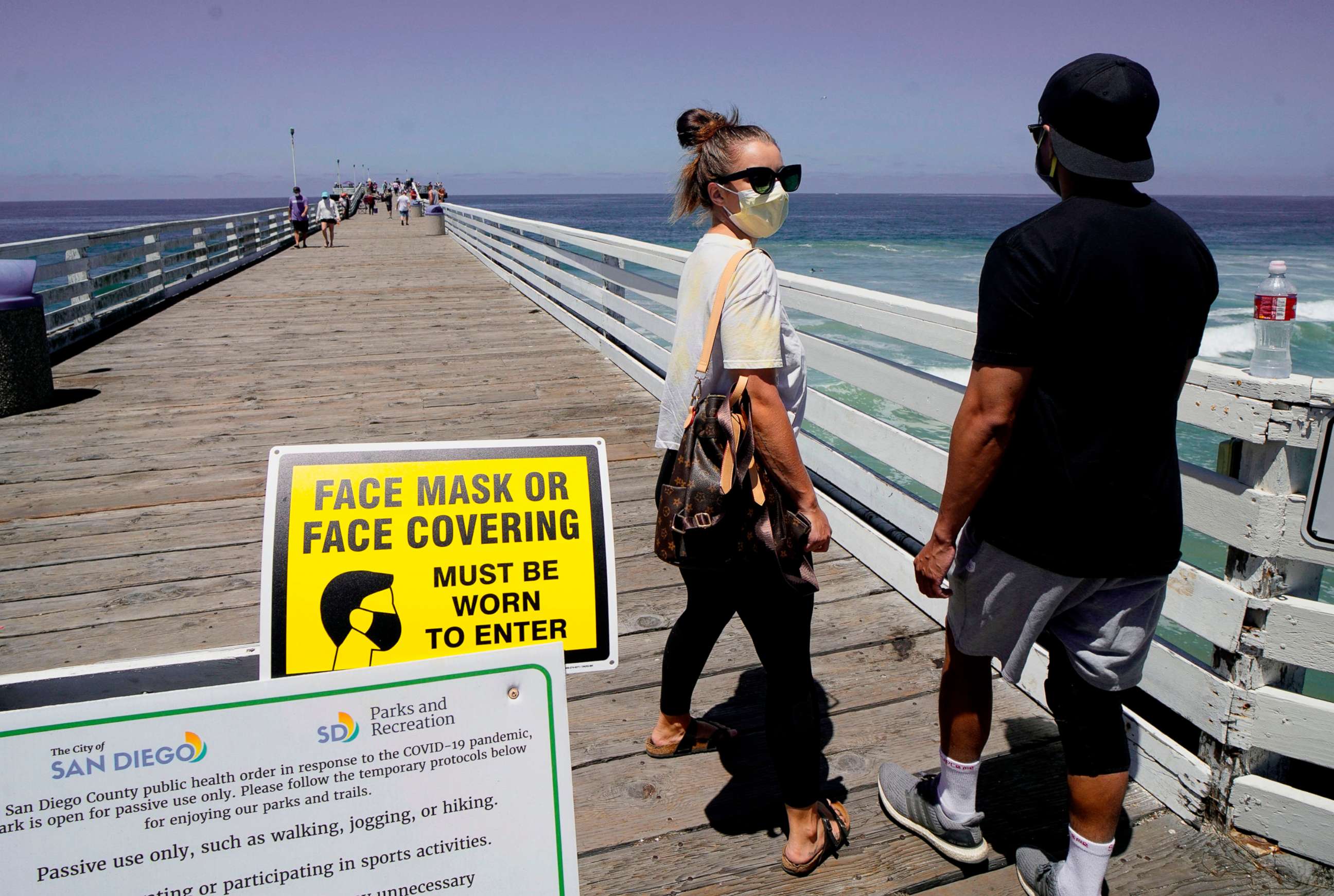PHOTO: BBeachgoers walk out onto the Pacific Beach Pier in San Diego, Calif., on July 4, 2020, amid the coronavirus pandemic.