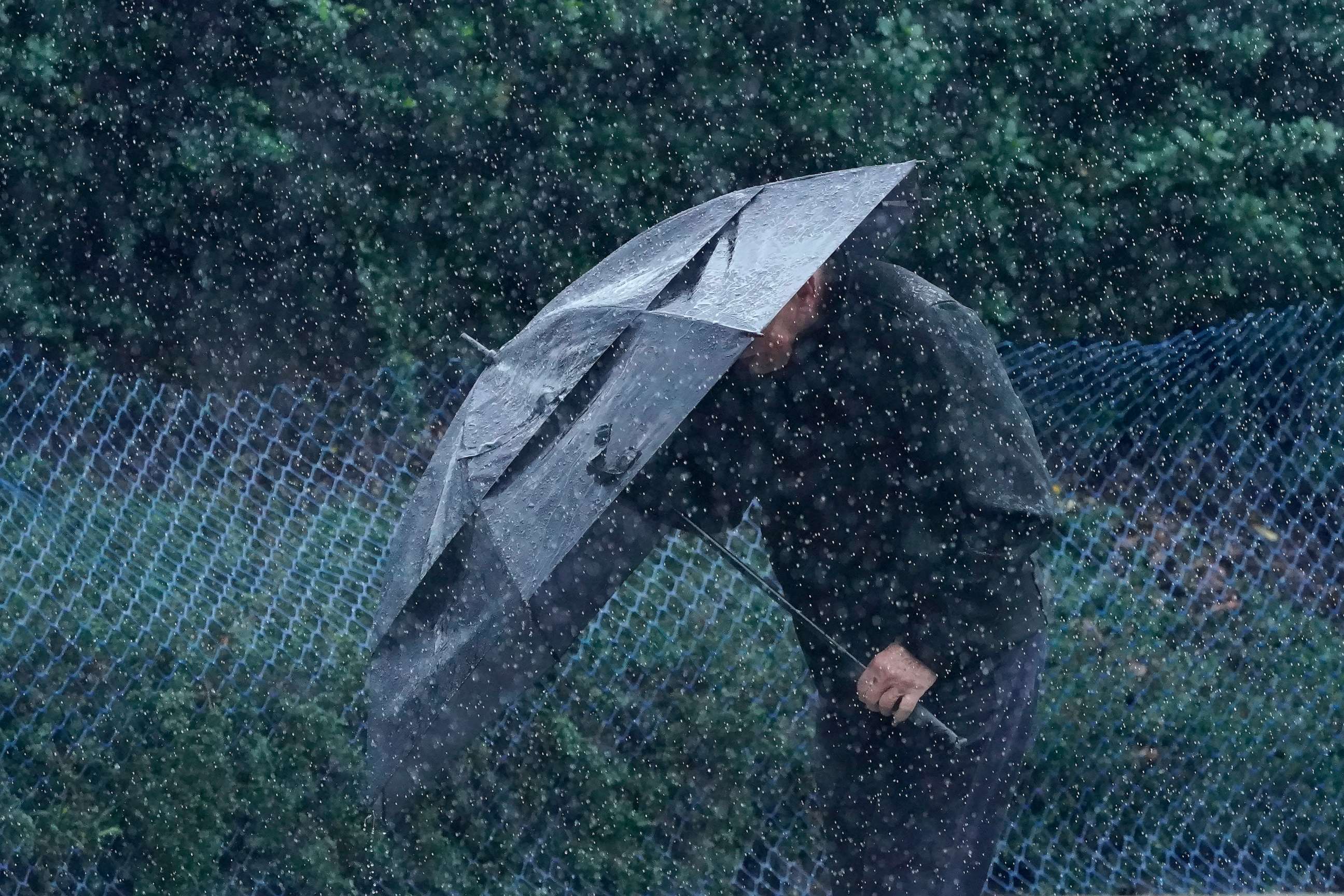 PHOTO: Rain falls as a pedestrian walks up a hill carrying an umbrella in San Francisco, Wednesday, Jan. 11, 2023.