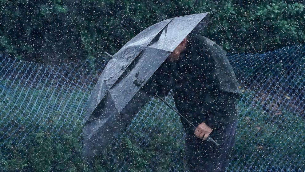 PHOTO: Rain falls as a pedestrian walks up a hill carrying an umbrella in San Francisco, Wednesday, Jan. 11, 2023.