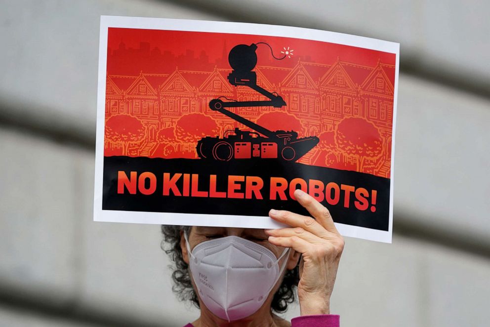 PHOTO: A woman holds up a sign while taking part in a demonstration about the use of robots by the San Francisco Police Department outside of City Hall in San Francisco, on Dec. 5, 2022.