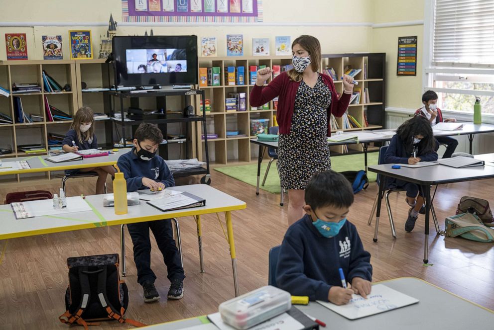 PHOTO: In this Oct. 5, 2020, file photo, a teacher wearing a protective mask speaks to students during a lesson at an elementary school in San Francisco.