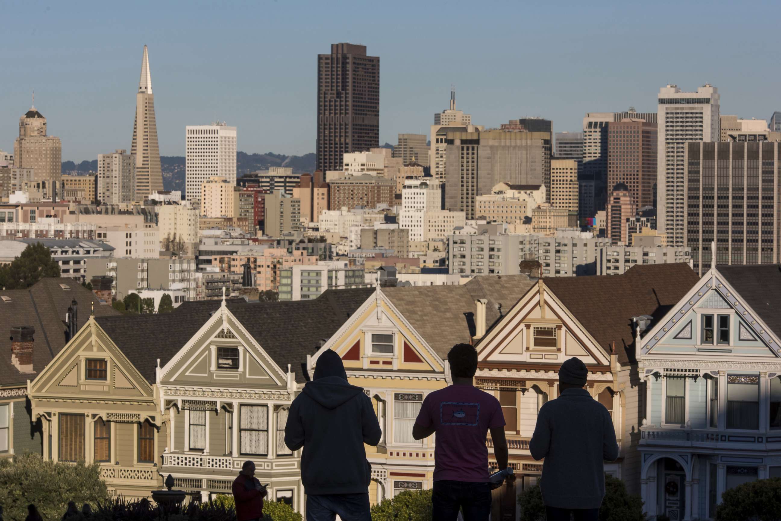 PHOTO: The silhouettes of pedestrians stand in front of Victorian homes and the downtown skyline in San Francisco, Dec. 29, 2015.