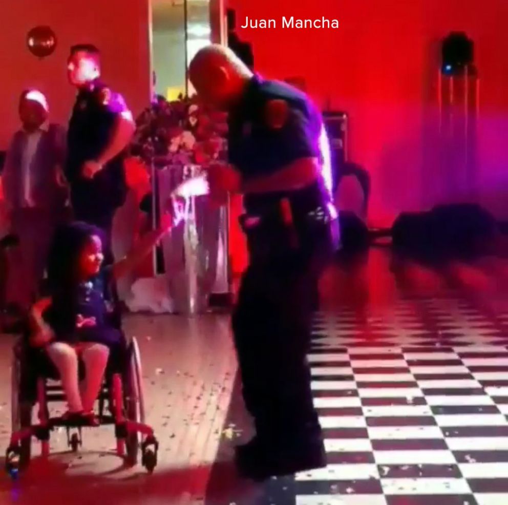 PHOTO: Houston police officer Sandy Fernandez dances with Saori, 5. Saori, who has spina bifada, requires the use of a wheelchair.