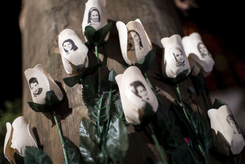 PHOTO: Pictures of victims of the Sandy Hook Elementary School shooting are seen on artificial roses at a roadside memorial, Dec. 20, 2012 in Newtown, Conn.