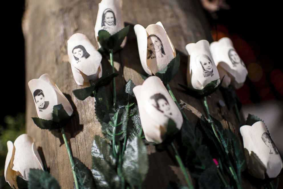 PHOTO: Pictures of victims of the Sandy Hook Elementary School shooting are seen on artificial roses at a roadside memorial on Dec. 20, 2012, in Newtown, Conn.