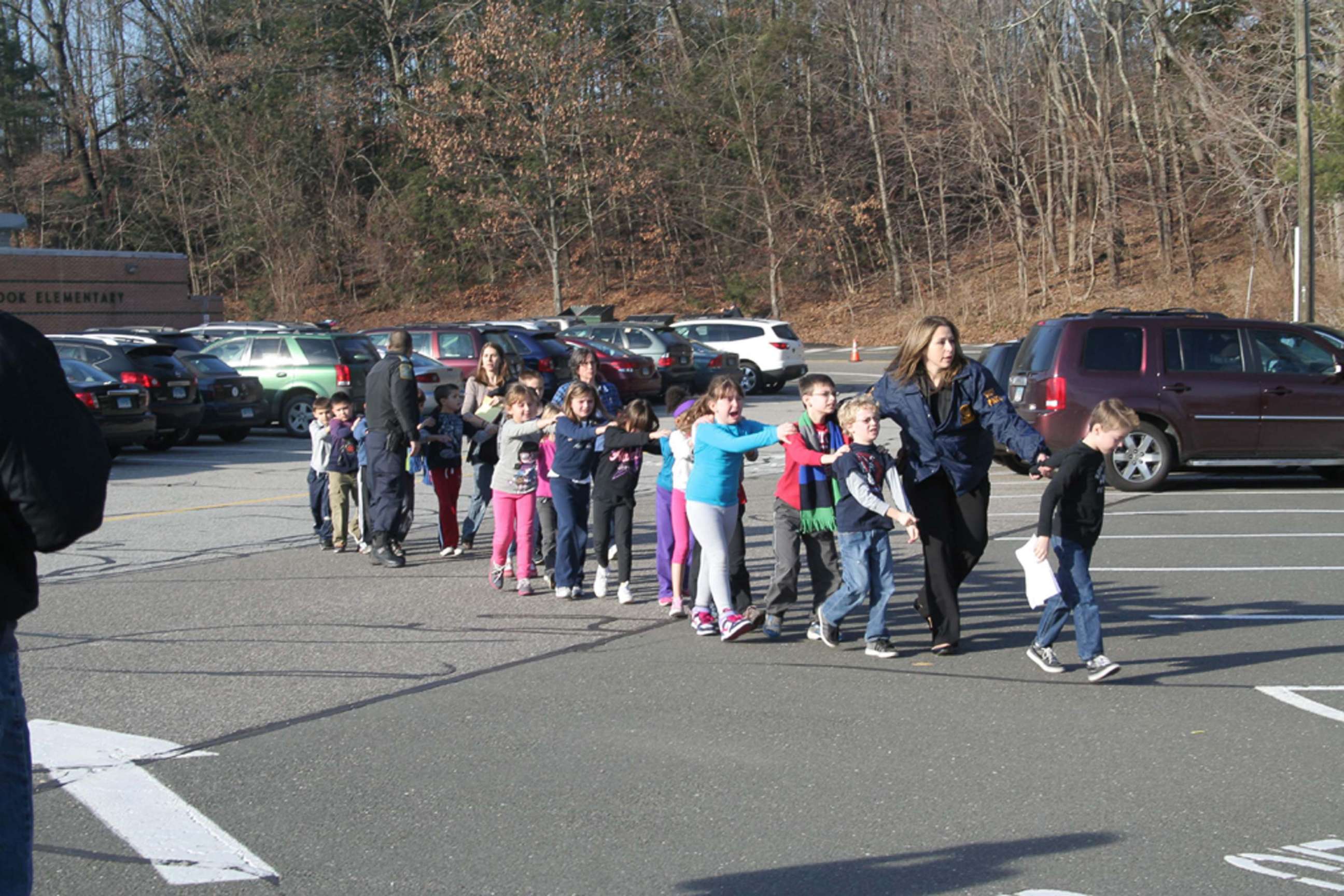 Two Connecticut State Police officers escort students and adults out of Sandy Hook Elementary School in Newtown, Conn., Dec. 14, 2012, after Adam Lanza, 20, entered the building and fatally shot 20 children and six adults before taking his own life.