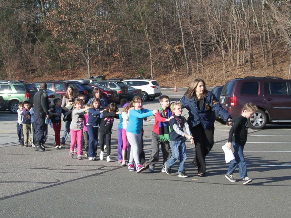Two Connecticut State Police officers escort students and adults out of Sandy Hook Elementary School in Newtown, Conn., Dec. 14, 2012, after Adam Lanza, 20, entered the building and fatally shot 20 children and six adults before taking his own life.