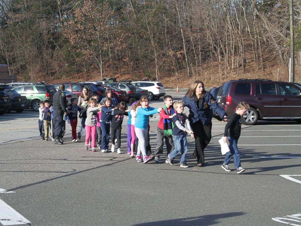 PHOTO: Two Connecticut State Police officers escort a class of students and two adults out of Sandy Hook Elementary School in Newtown, Conn., Dec. 14, 2012.